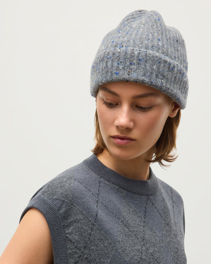 A woman wearing a gray ribbed knit beanie with subtle blue flecks and a matching gray knit sweater, photographed against a plain light gray background. JOHNSTONS OF ELGIN CASHMERE DONEGAL TRAQUAIR RIBBED BEANIE GREY 100% CASHMERE HAE03643HA4270ONE