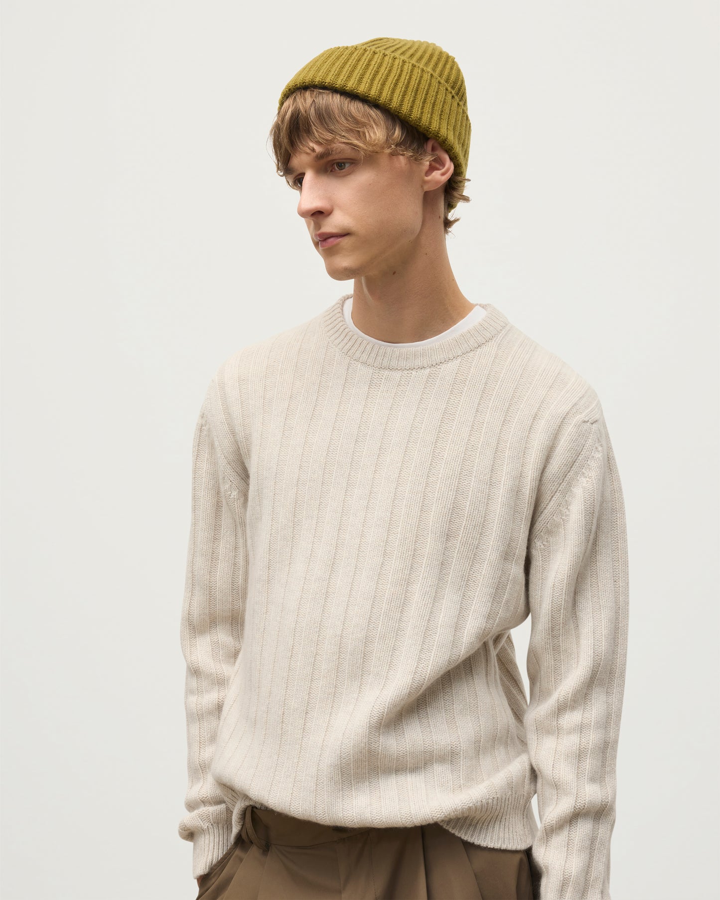 JOHNSTONS OF ELGIN LOVAT HAT GREEN 100% CASHMERE ON AM ALE MODEL WEARING PEEL CASHMERE SWEATER IN NATURAL HAY03614SC4719ONE