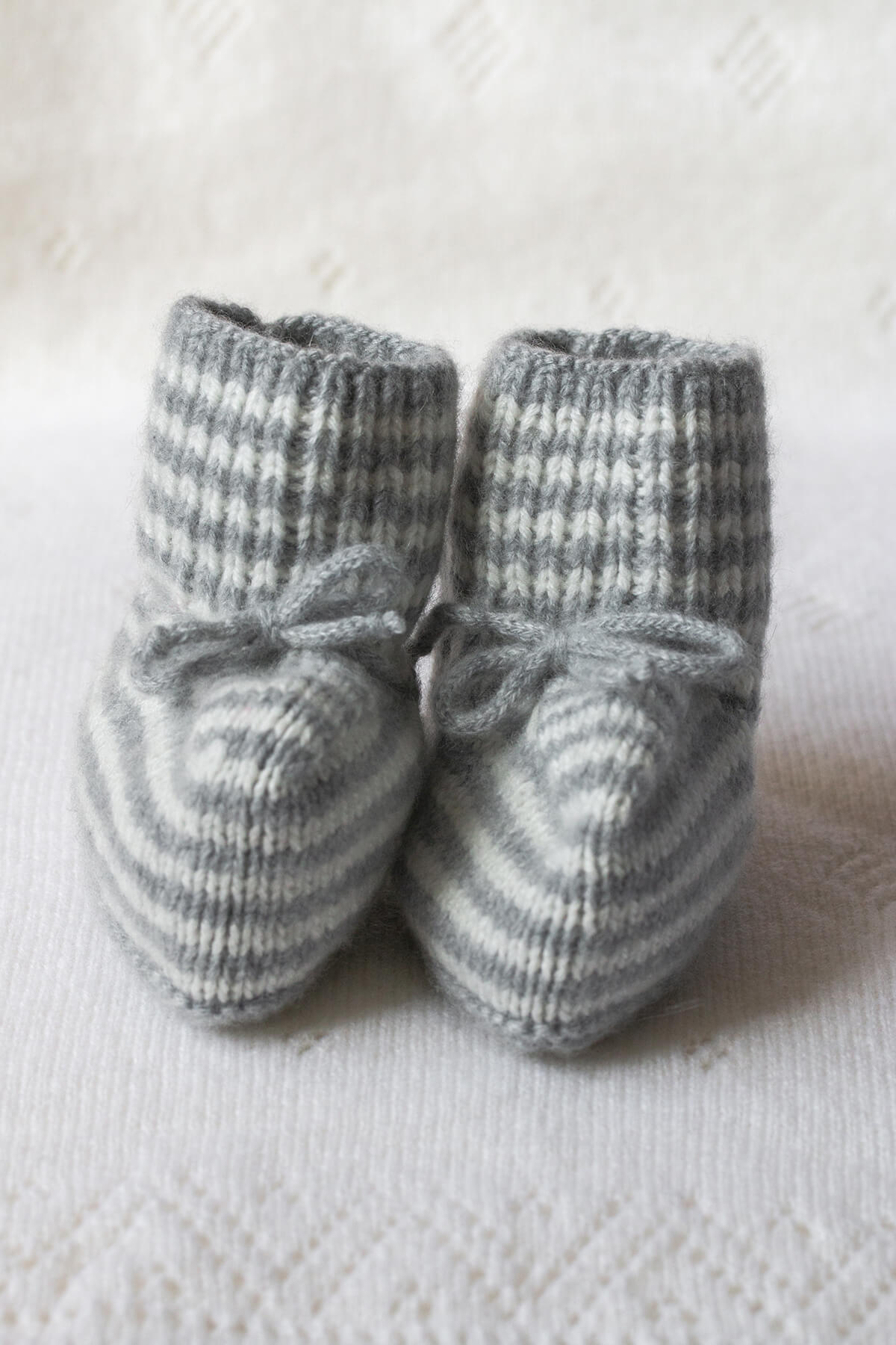 Johnstons of Elgin Hand Knitted Cashmere Baby Booties with crotched trims in Silver & White on a white Cashmere Baby Blanket background 746334243