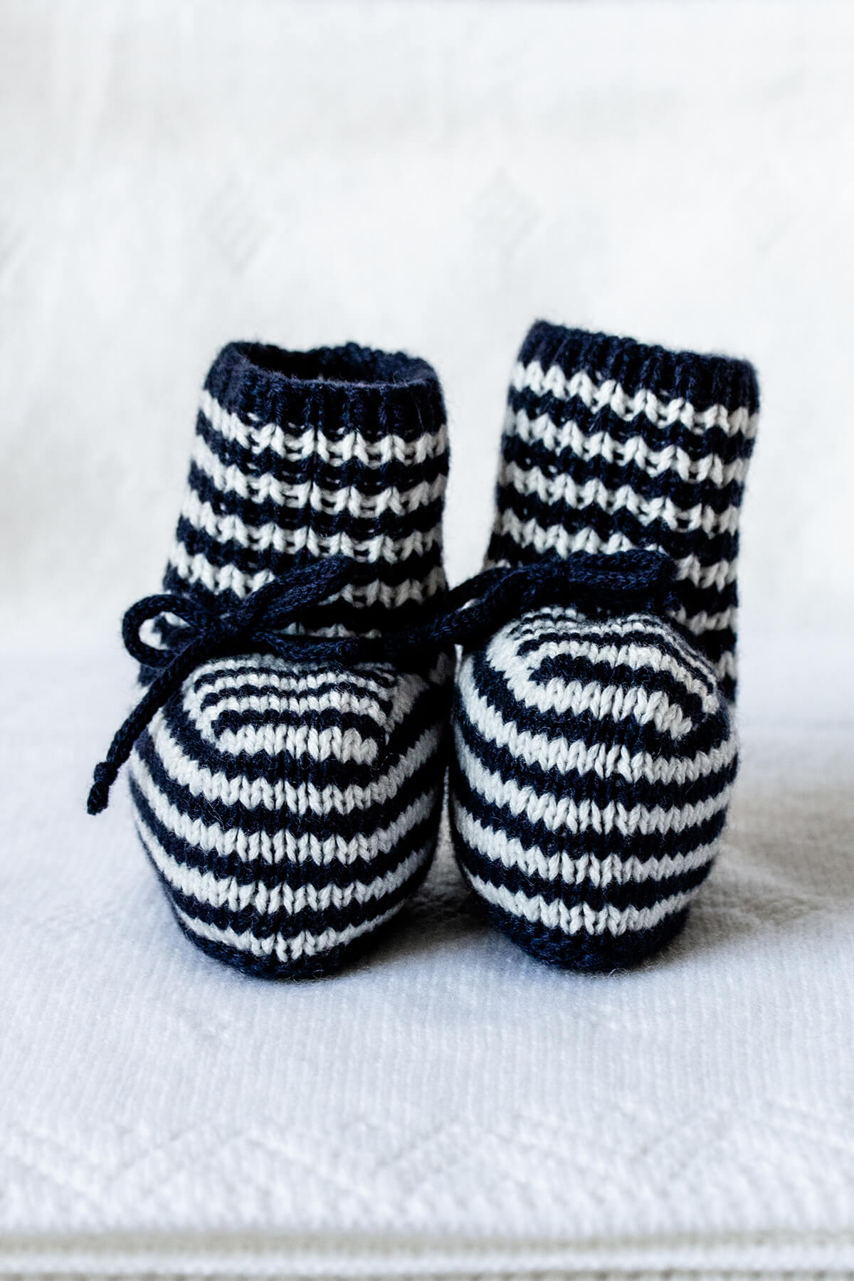 Johnstons of Elgin Hand Knitted Cashmere Baby Booties with crotched trims in Navy & White on a white Baby Blanket background 746330333