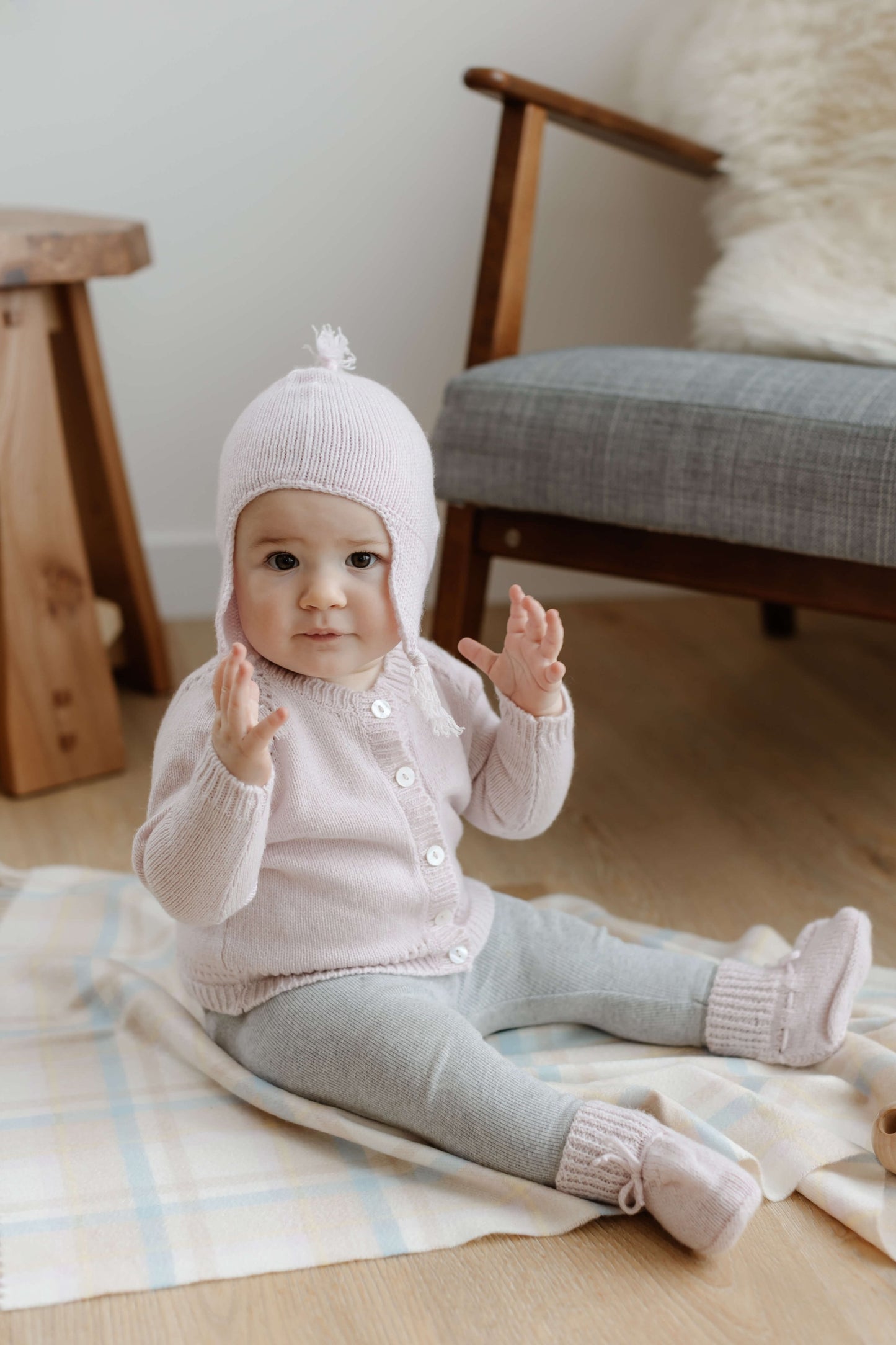 Johnstons of Elgin Hand Knitted Cashmere Baby Booties in Blush on pink check background 61711P191ONE