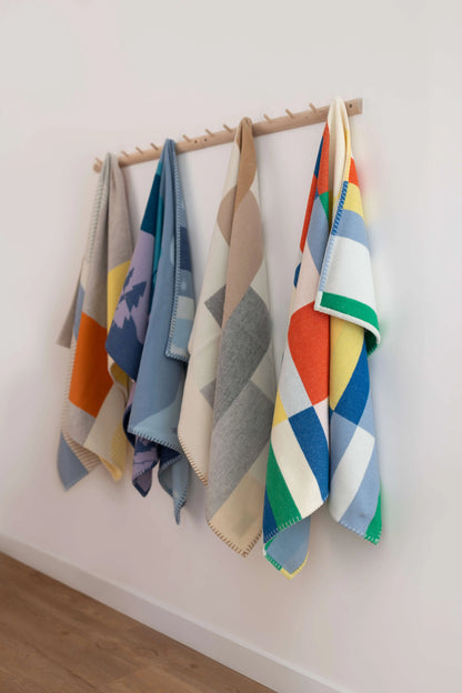 2025 Johnstons of Elgin Interiors Collection Children's Blanket Collection hanging on wooden pegs on a white wall TB000582RU7439ONE