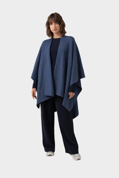 Johnstons of Elgin Double Face Donegal Cashmere Cape in Denim worn with Navy Cashmere Sweater and Wide Leg Joggers on a grey background KAA05102Q23736ONE