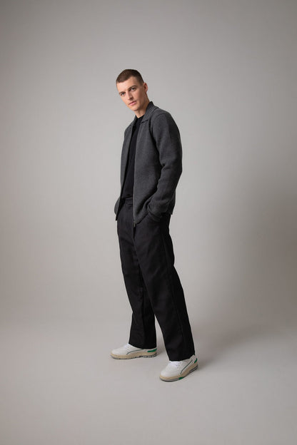 Johnstons of Elgin’s Men's Milano Stitch Cashmere Zip Jacket in Charcoal grey on model wearing black trousers on a grey background KAA05113HA7165