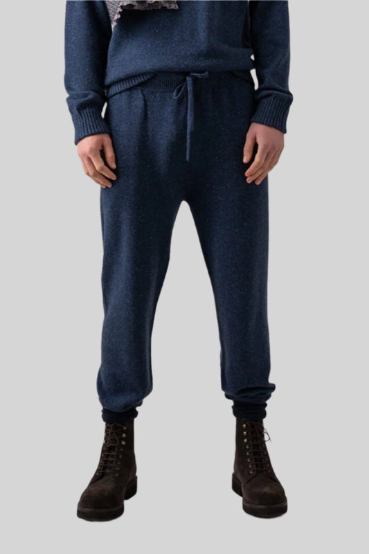 Johnstons of Elgin’s Men's Cashmere Donegal Joggers in Denim blue on model wearing matching blue cashmere jumper on a grey background KAI05146004544