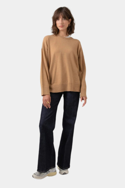 Johnstons of Elgin Women's Round Neck Fair Isle Back Jumper in Camel worn with Jeans on a grey background KAA05152Q23722