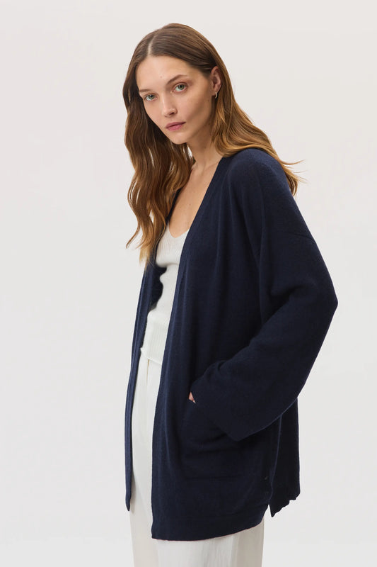 Model wearing Johnstons of Elgin SS25 Women's Knitwear Navy Cashmere Kimono Cardigan with our white superfine cashmere vest on a white background  KAA05207SD7286