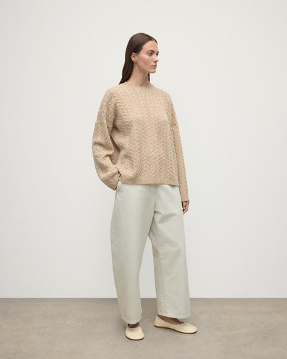 Model wearing Johnstons of Elgin Women's Knitwear Oatmeal Slouchy Cable Natural Cashmere Jumper Side View KAA05282HB0210