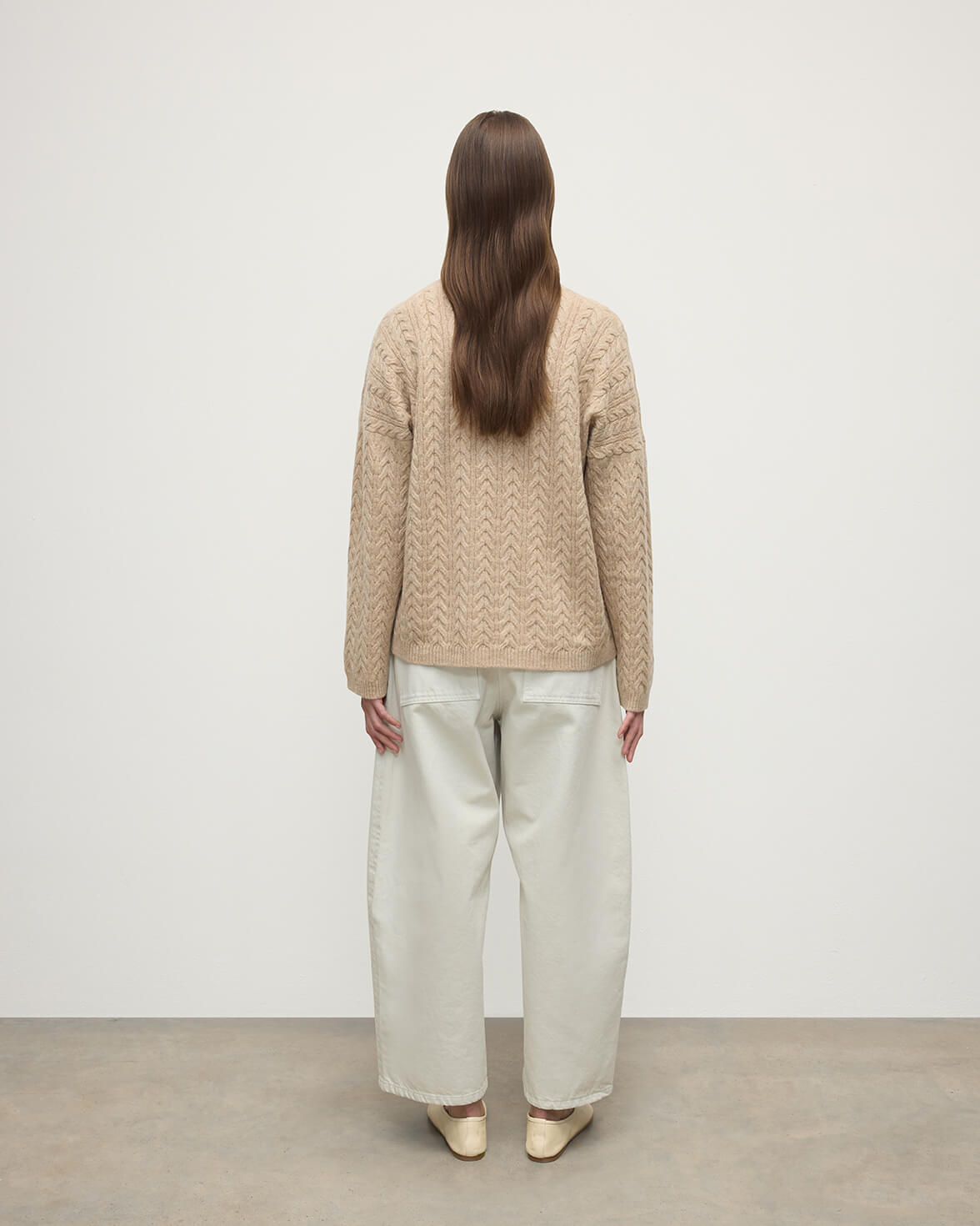 Model wearing Johnstons of Elgin Women's Knitwear Oatmeal Slouchy Cable Natural Cashmere Jumper Back View KAA05282HB0210