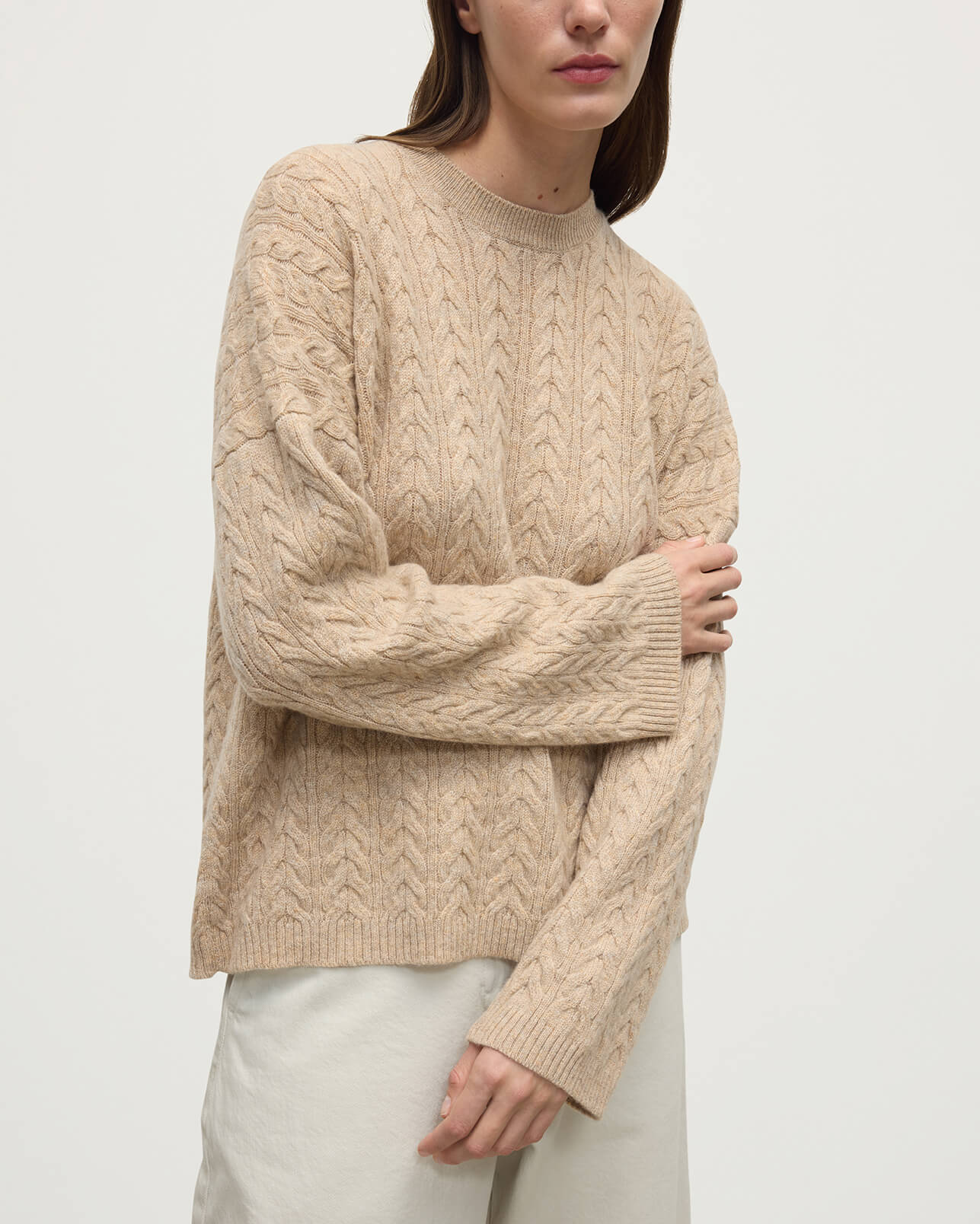 Model wearing Johnstons of Elgin Women's Knitwear Oatmeal Slouchy Cable Natural Cashmere Jumper Close Up KAA05282HB0210