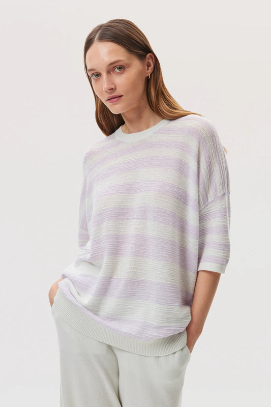 Female model wearing Johnstons of Elgin SS25 Unisex Knitwear White & Lavender Textured Stripe Oversized Cashmere T-Shirt on a white background KAA05414Q25126