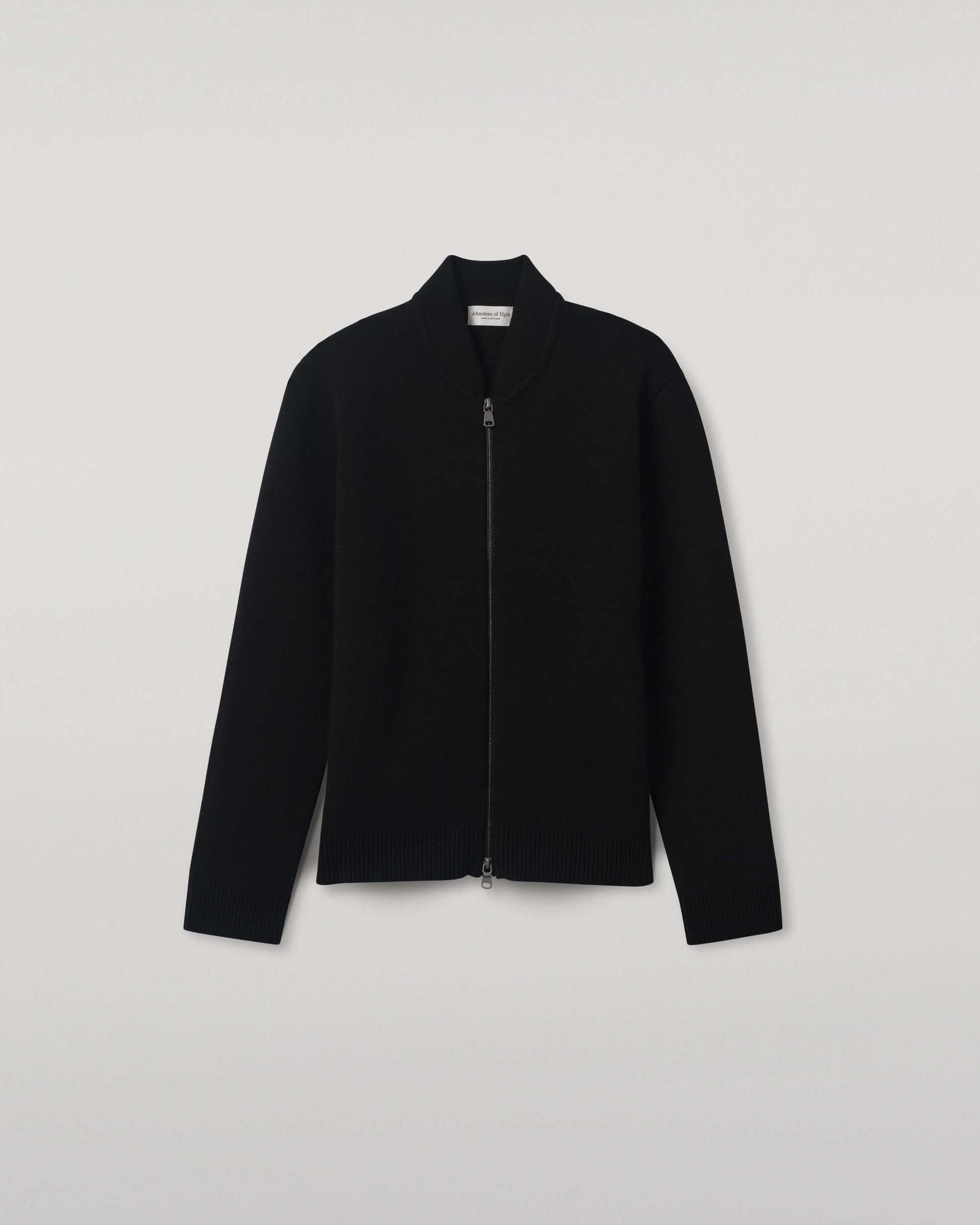 Johnstons of Elgin AW25 Men's Knitwear Black Cashmere Milano Stitch Zip Jacket with black trousers and a white t-shirt  KAA05443SA0900