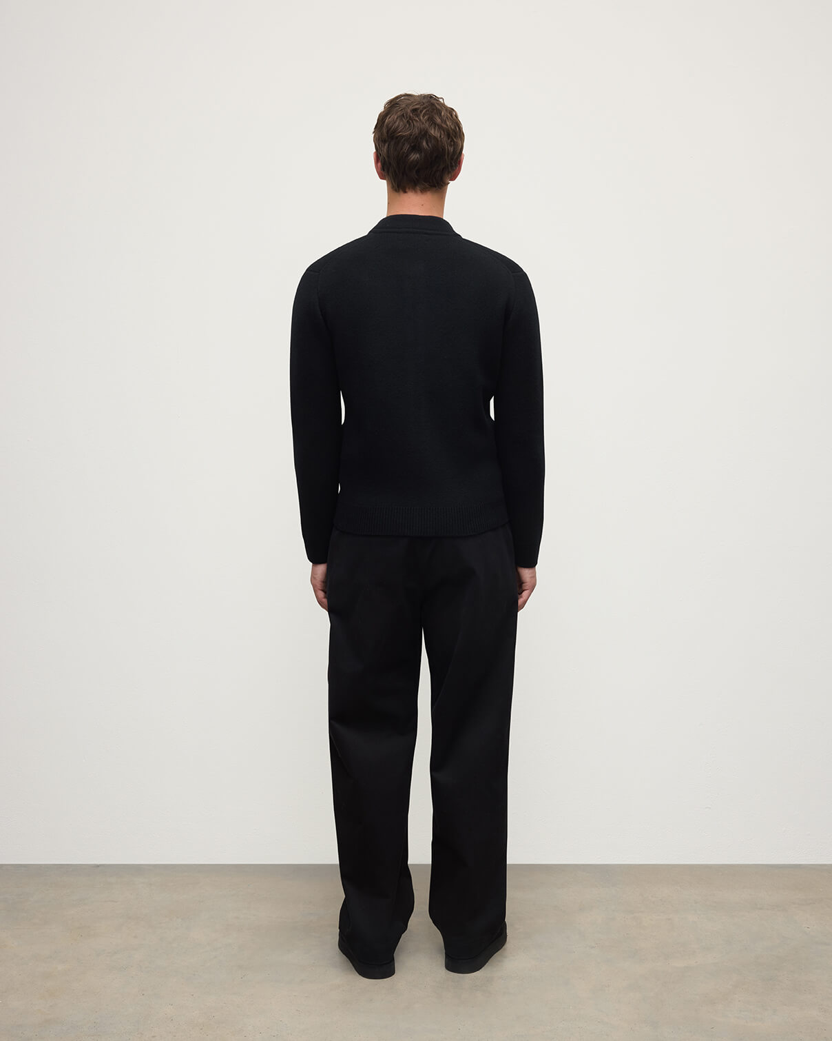 Johnstons of Elgin AW25 Men's Knitwear Black Cashmere Milano Stitch Zip Jacket with black trousers and a white t-shirt  KAA05443SA0900