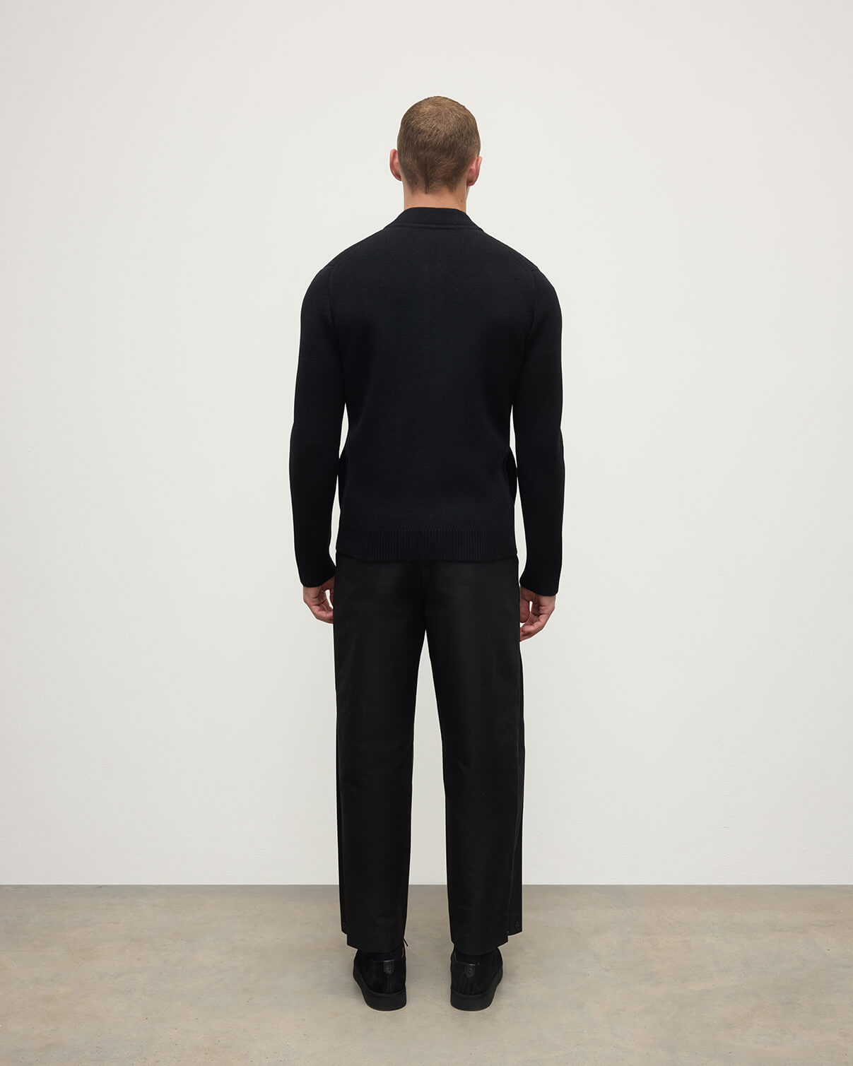 Back view of a model wearing Johnstons of Elgin AW25 Men's Knitwear Black Milano Ribbed Zip Black Cashmere Cardigan KAA05443SA7210