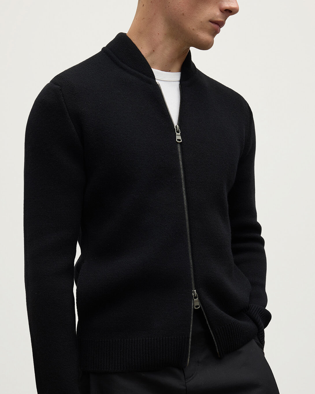 Close up of a model wearing Johnstons of Elgin AW25 Men's Knitwear Black Milano Ribbed Zip Black Cashmere Cardigan KAA05443SA7210