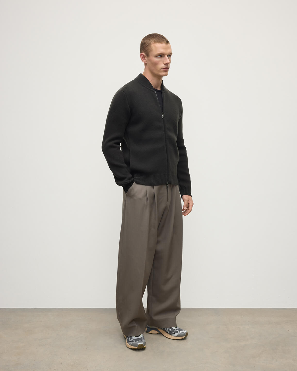 Side view model wearing Johnstons of Elgin AW25 Men's Knitwear Black Milano Ribbed Zip Black Cashmere Cardigan KAA05443SC7330