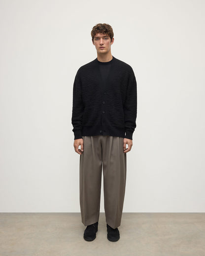 Model wearing Johnstons of Elgin AW25 Men's Knitwear Black & Iron Plaited Texture Black Cashmere Cardigan Front View KAA05579Q25387