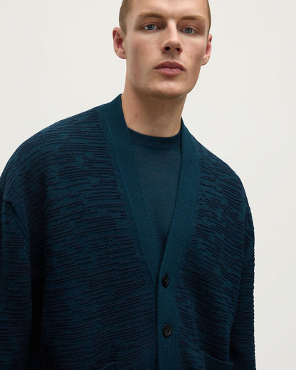 Close up of model wearing Johnstons of Elgin AW25 Men's Knitwear Bottle Green & Dark Navy Plaited Texture Green Cashmere Cardigan KAA05579Q25389