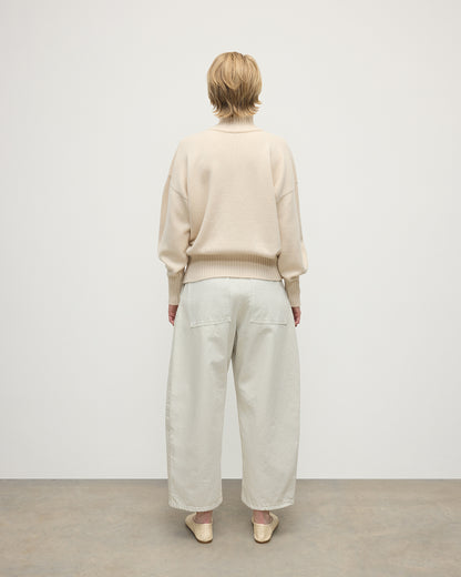 Model wearing Johnstons of Elgin AW25 Women's Knitwear Champagne High Neck Cream Cashmere Jumper Back View  KAA05585SA0502