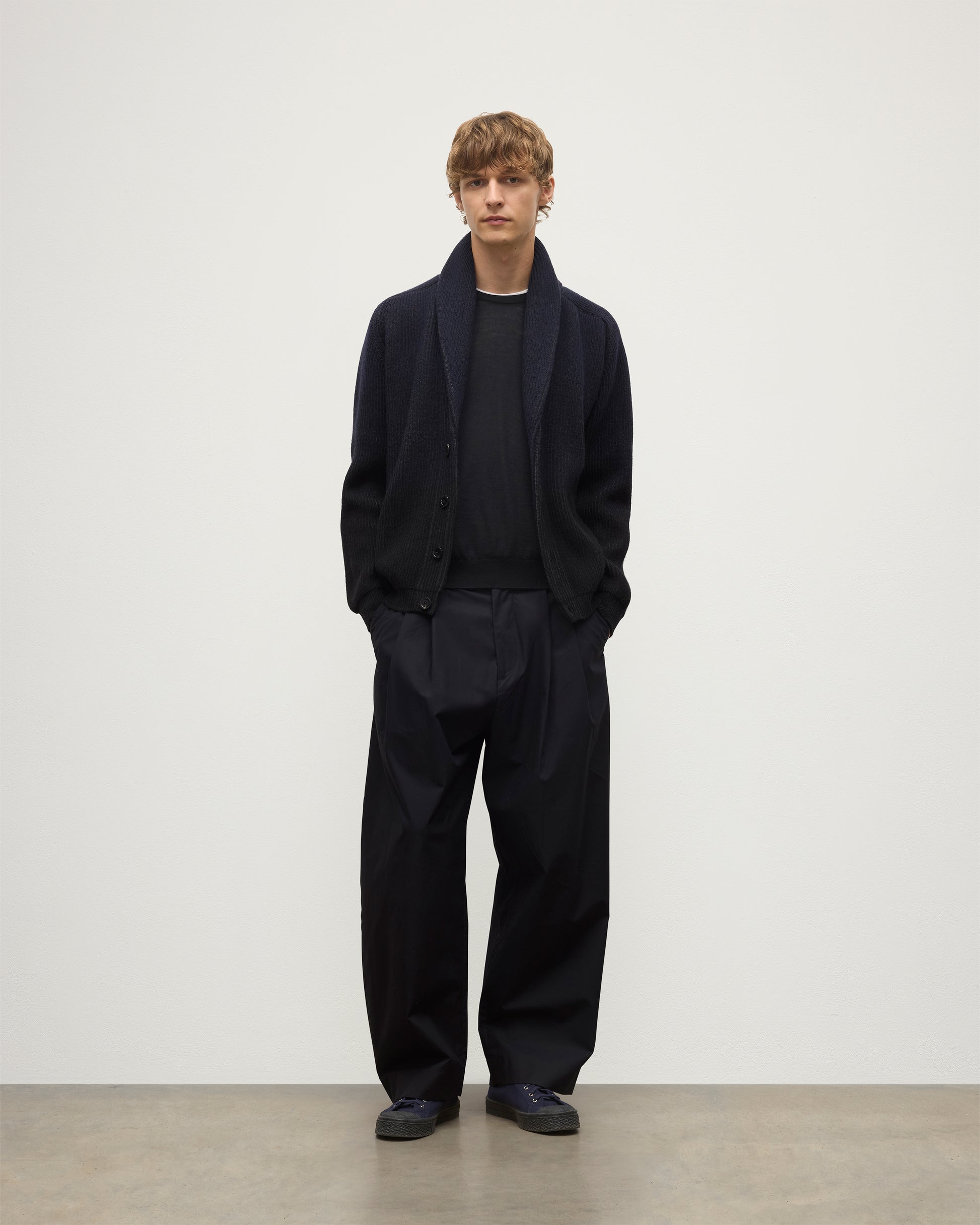 MALE MODEL WEARING JOHNSTONS OF ELGIN PIONEER SHAWL CARDIGAN NAVY & BLACK 100% CASHMERE WITH BLACK SUPERFINE CASHMERE SWEATER AND NAVY TROUSERS KAA05750Q25947