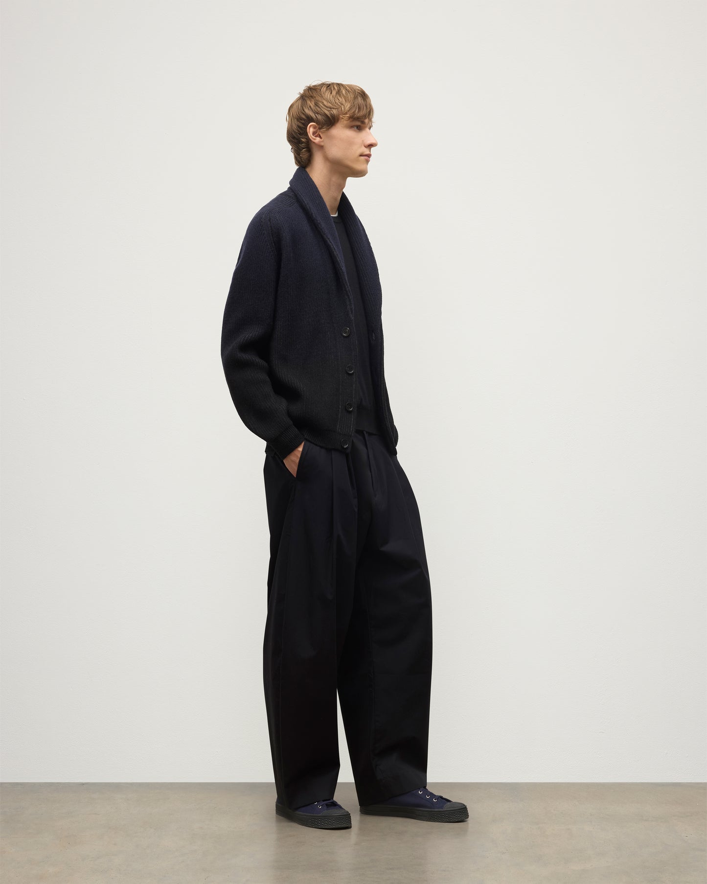 MALE MODEL WEARING JOHNSTONS OF ELGIN PIONEER SHAWL CARDIGAN NAVY & BLACK 100% CASHMERE WITH BLACK SUPERFINE CASHMERE SWEATER AND NAVY TROUSERS KAA05750Q25947