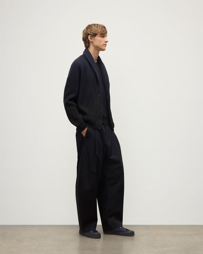 MALE MODEL WEARING JOHNSTONS OF ELGIN PIONEER SHAWL CARDIGAN NAVY & BLACK 100% CASHMERE WITH BLACK SUPERFINE CASHMERE SWEATER AND NAVY TROUSERS KAA05750Q25947