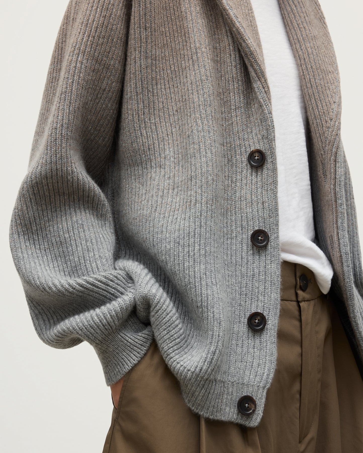 FEMALE MODEL WEARING JOHNSTONS OF ELGIN PIONEER SHAWL CARDIGAN GREY 100% CASHMERE WITH WHITE T-SHIRT DETAILS  UAA05750Q25948