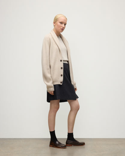 FEMALE MODEL WEARING JOHNSTONS O F ELGIN PIONEER SHAWL CARDIGAN NATURAL 100% CASHMERE WITH MATCHING CASHMERE SWEATER AND CHARCOAL SHORT LE KILT SKIRT & LOAFERS UAA05750Q26191
