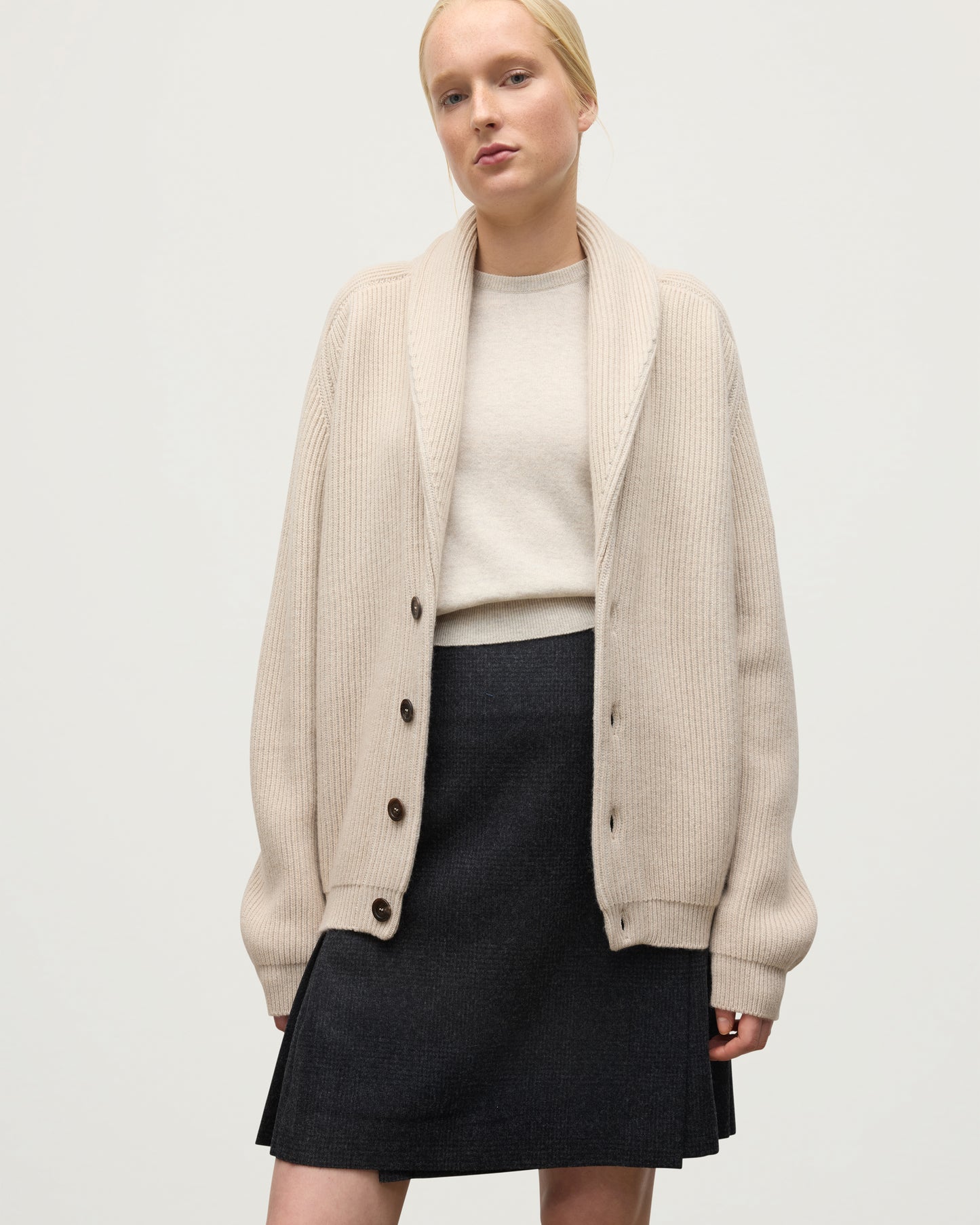 FEMALE MODEL WEARING JOHNSTONS O F ELGIN PIONEER SHAWL CARDIGAN NATURAL 100% CASHMERE WITH MATCHING CASHMERE SWEATER AND CHARCOAL SHORT LE KILT SKIRT UAA05750Q26191