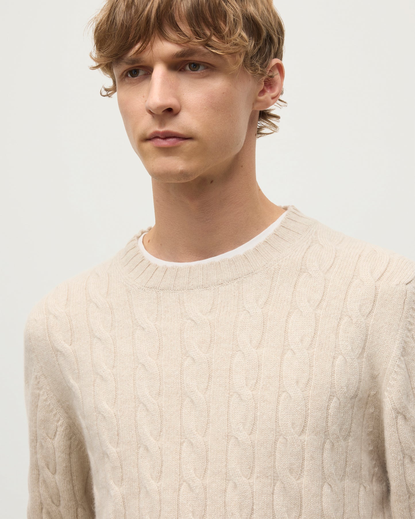 JOHNSTONS OF ELGIN MENS CALDER CREW SWEATER CREAM 100% CASHMERE WORN BY A MODEL, OVER A WHITE T-SHIRT & NAVY TROUSERS KAA05754HA0396
