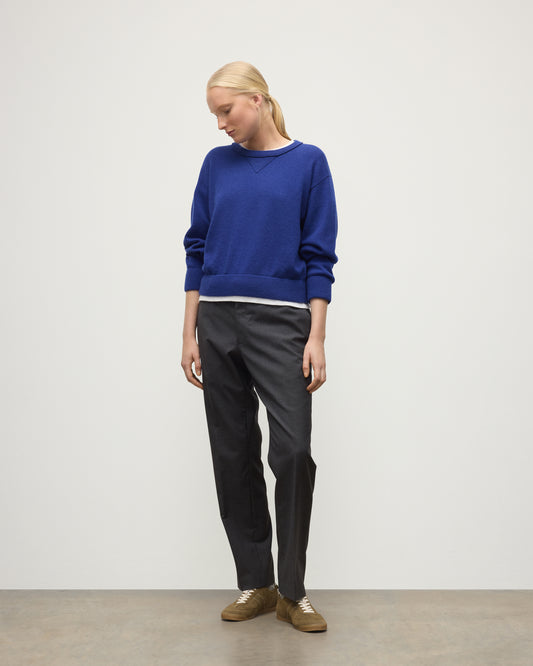 MODEL WEARING JOHNSTONS OF ELGIN WOMENS STELLA SWEATSHIRT BLUE 100% CASHMERE OVER A WHITE T_SHIRT, WITH DARK GREY TROUSERS KAA05770SD5326