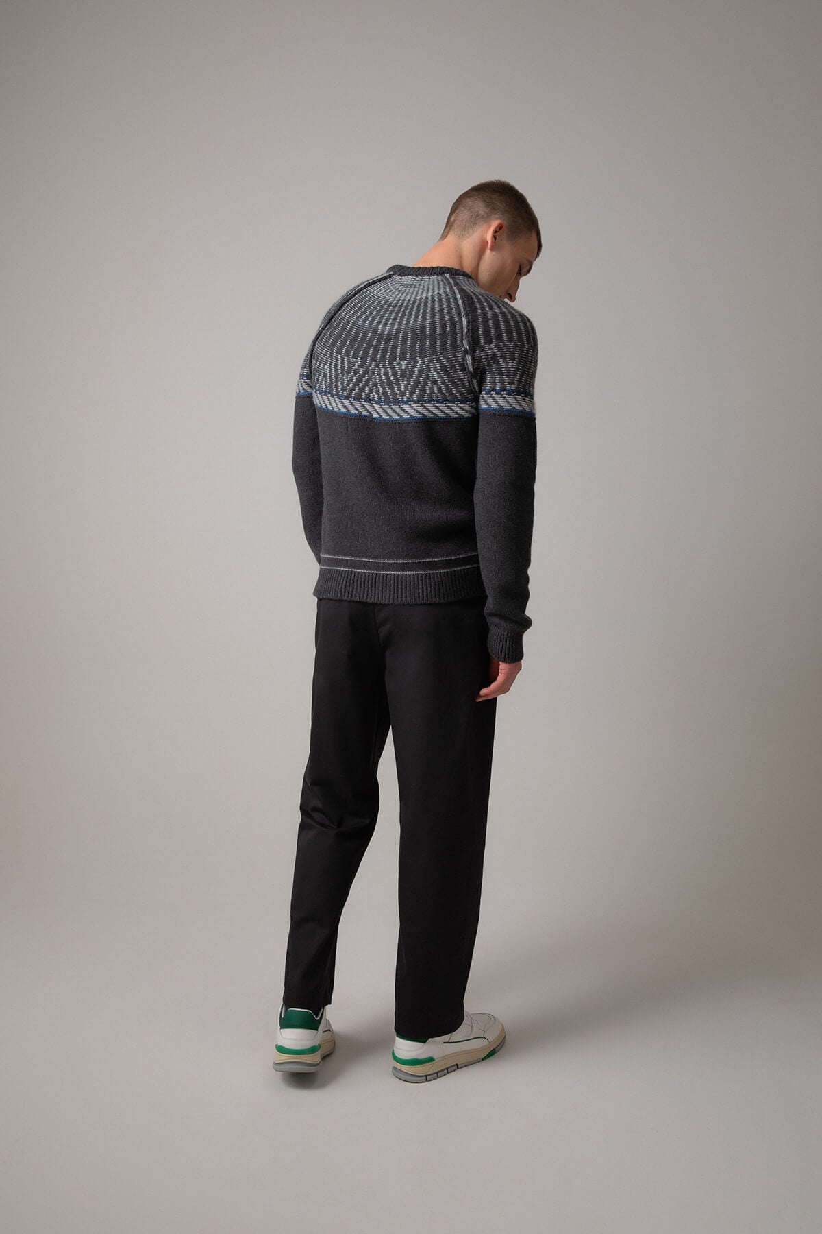 Johnstons of Elgin’s Men's Fairisle Yoke Cashmere Jumper in Charcoal grey on model wearing black trousers on a grey background KAB05108Q23714
