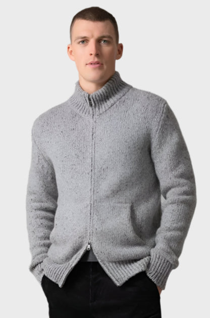 Johnstons of Elgin’s Men's Cashmere Donegal Zip Turtle Neck Cardigan in Light Grey on model wearing black trousers on a grey background KAB05115Q23711