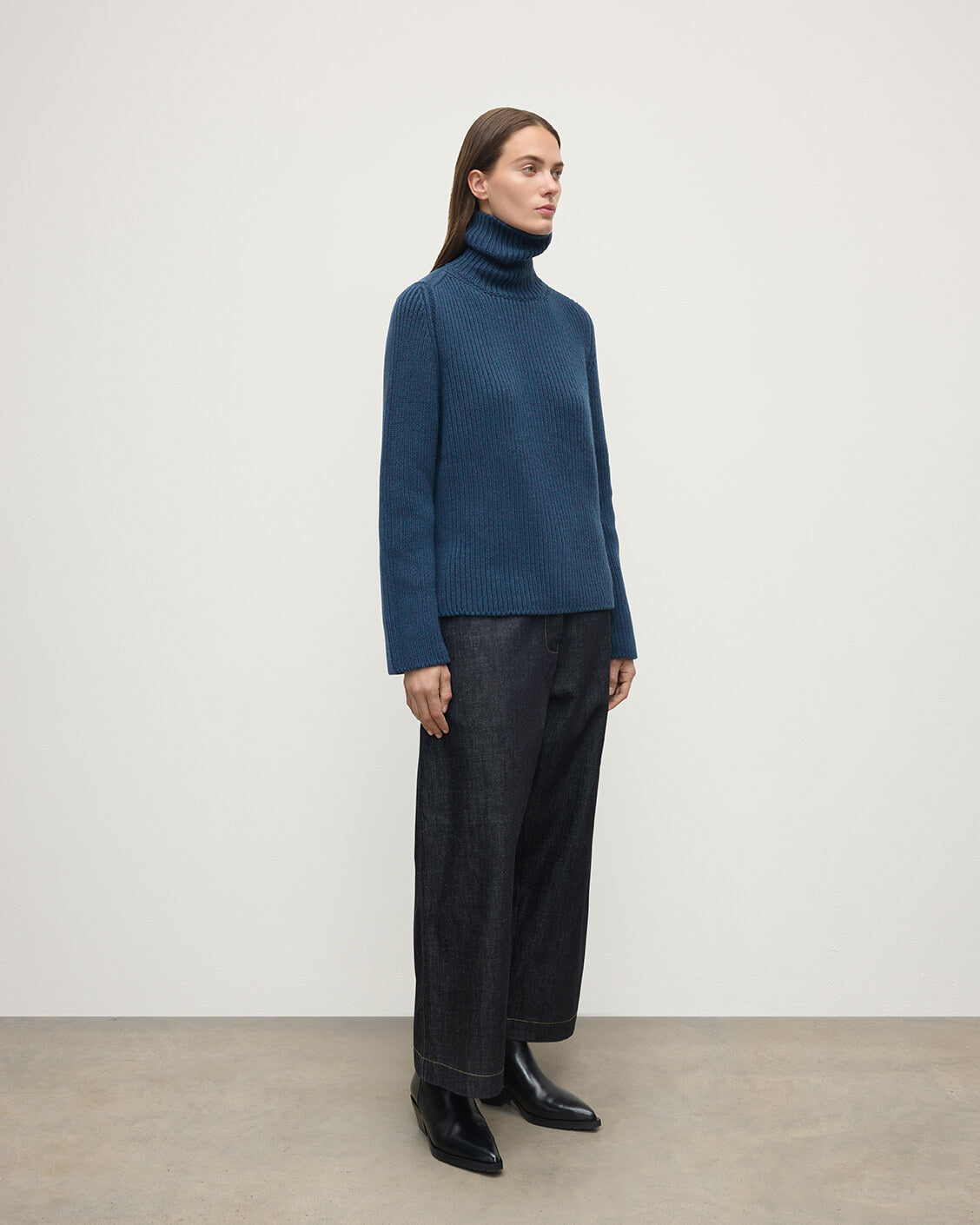 Model wears Johnstons of Elgin AW25 Women's Knitwear Heather Navy Roll-Collar Navy Cashmere Jumper Side View KAB05492HD7321