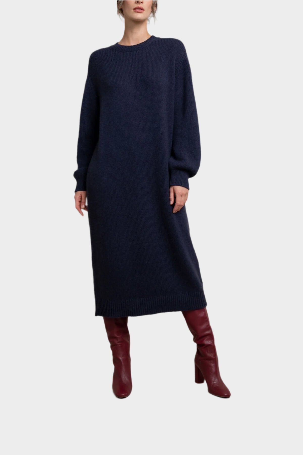 Model wearing Johnstons of Elgin Women’s Cashmere Sweater Dress in Navy a grey background KAC05045SD0707