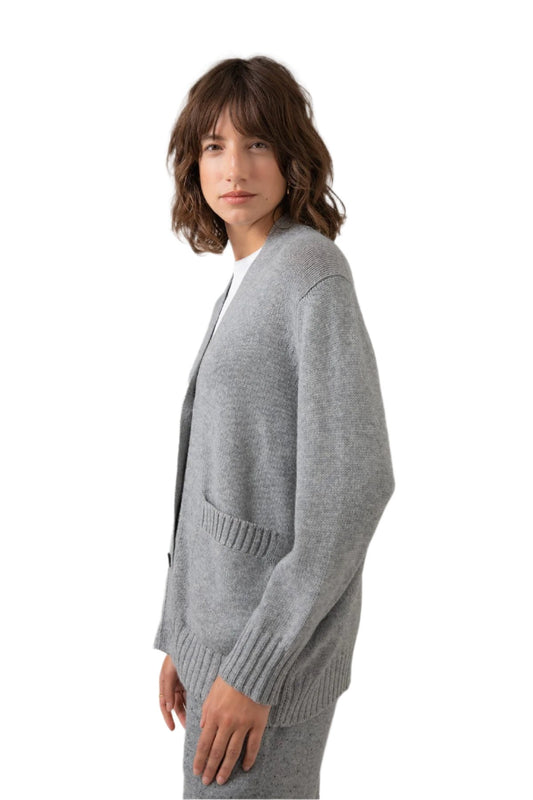 Side view of a Johnstons of Elgin Women's Relaxed Fit Cashmere Cardigan in Light Grey worn with a White T-Shirt KAC05087HA0308