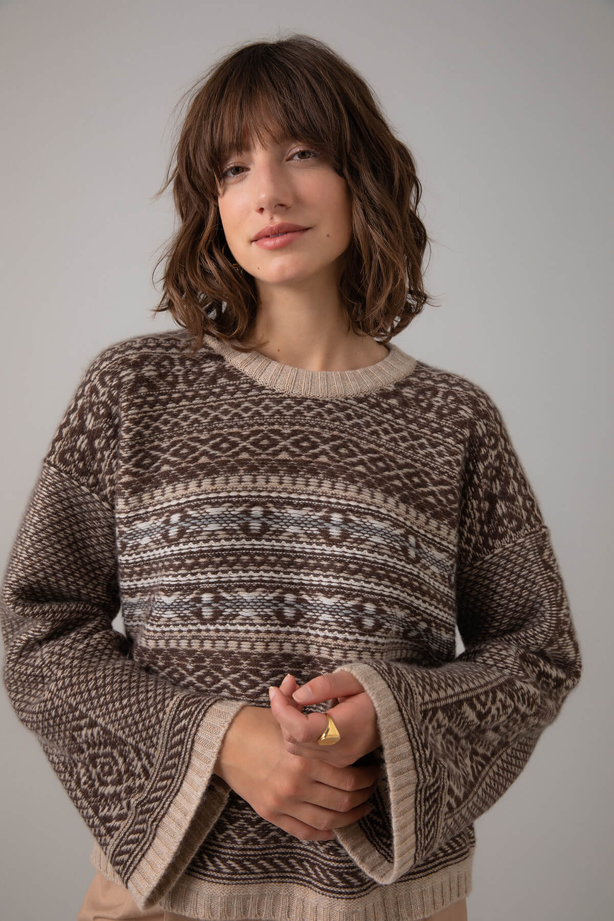 Johnstons of Elgin Women's Round Neck Traditional Sanquhar Fairisle Cashmere Sweater in Oatmeal on a grey background KAC05099Q23724