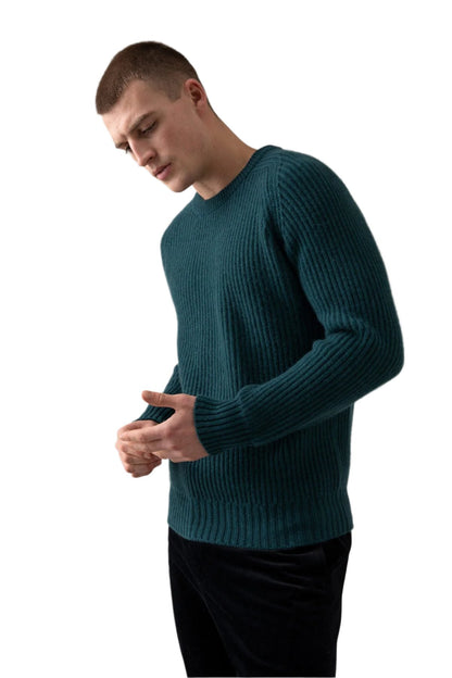 Johnstons of Elgin’s Men's Cashmere Ribbed Round Neck Jumper in Mallard green on model wearing black trousers on a grey background KAC05109HC7126