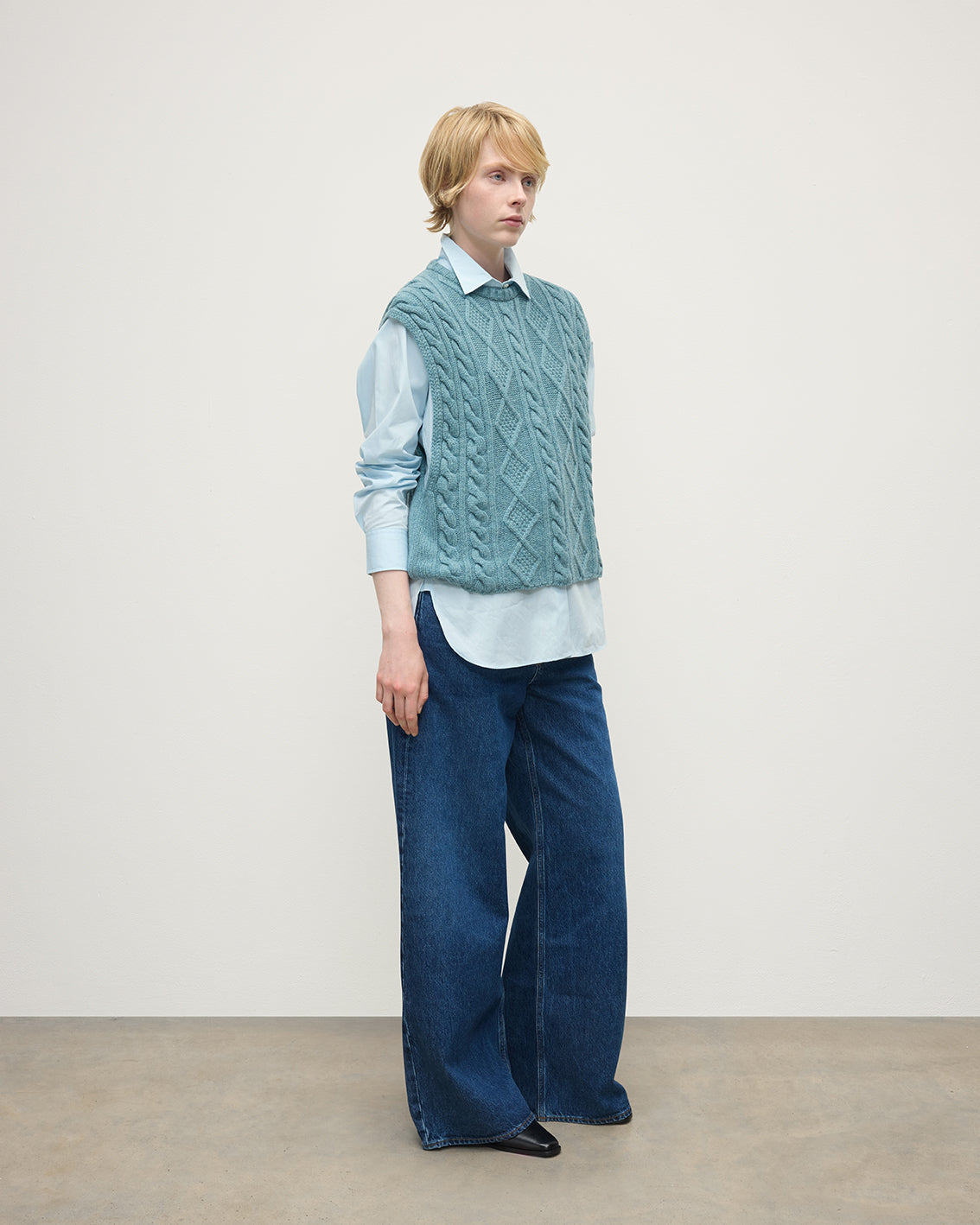 Model wears Johnstons of Elgin AW25 Women's Knitwear Seascape Aran Cable Green Cashmere Tank Side View KAC05321HC0038