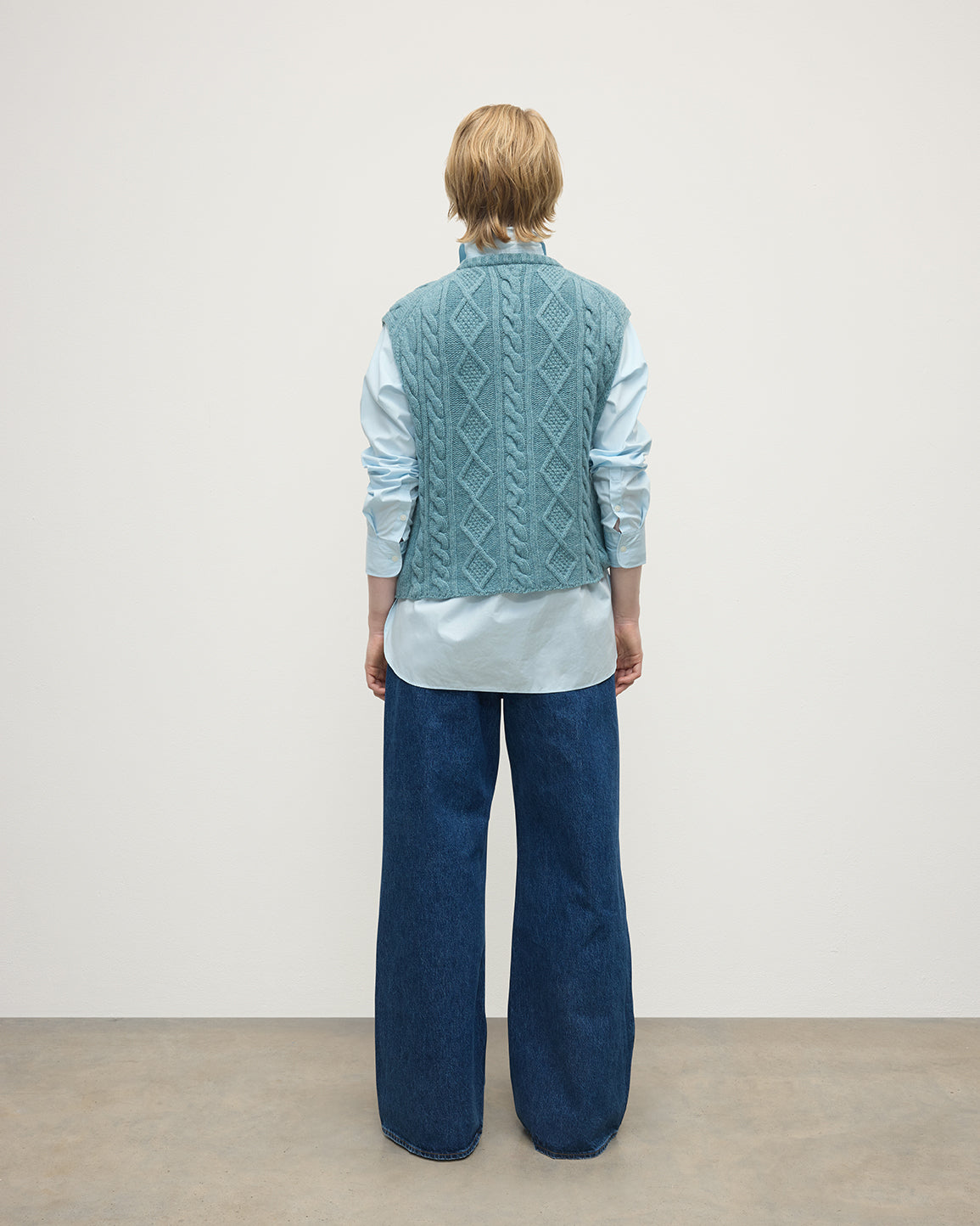 Model wears Johnstons of Elgin AW25 Women's Knitwear Seascape Aran Cable Green Cashmere Tank Back View KAC05321HC0038