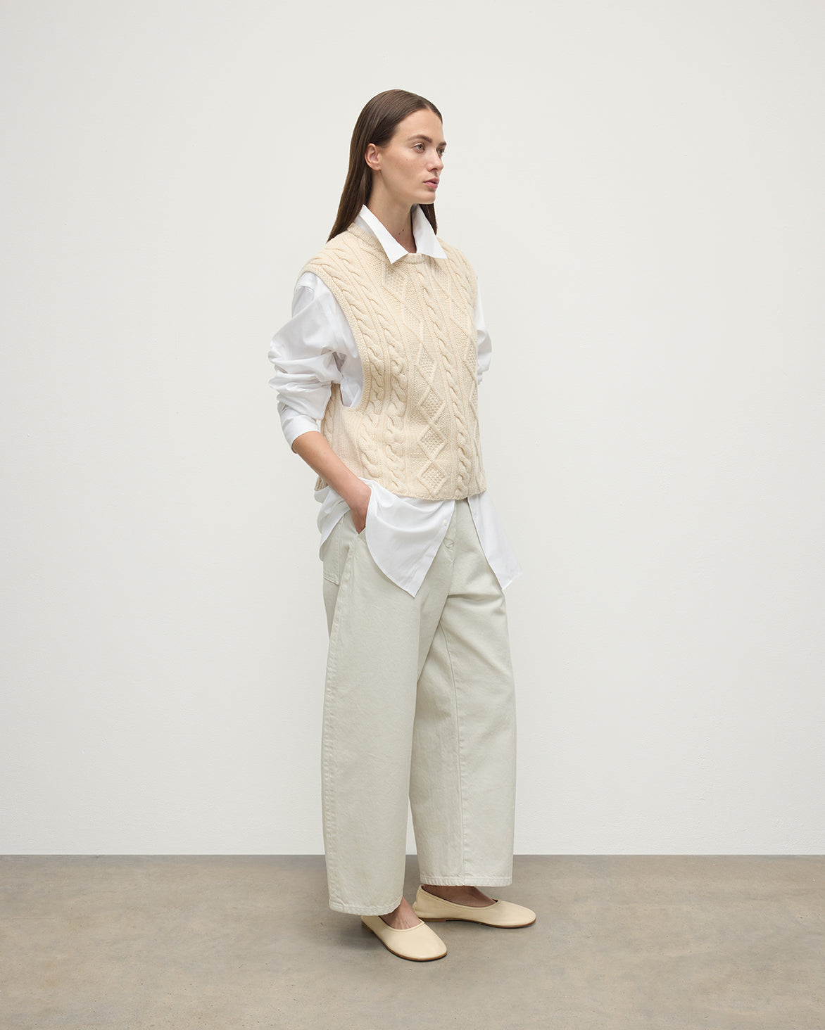 Model wears Johnstons of Elgin AW25 Women's Knitwear Champagne Aran Cable Cream Cashmere Tank Side View KAC05321SA0502