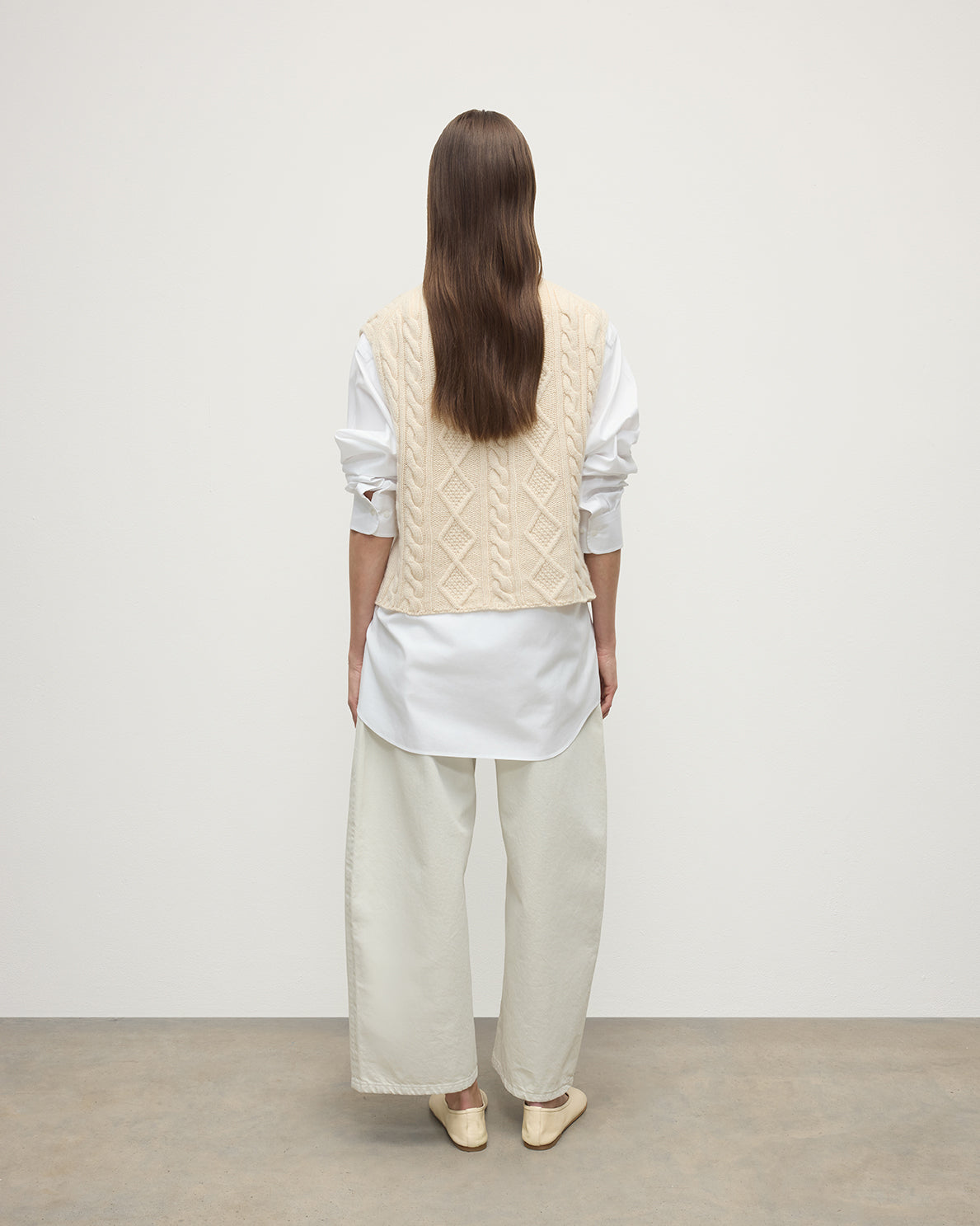 Model wears Johnstons of Elgin AW25 Women's Knitwear Champagne Aran Cable Cream Cashmere Tank back View KAC05321SA0502