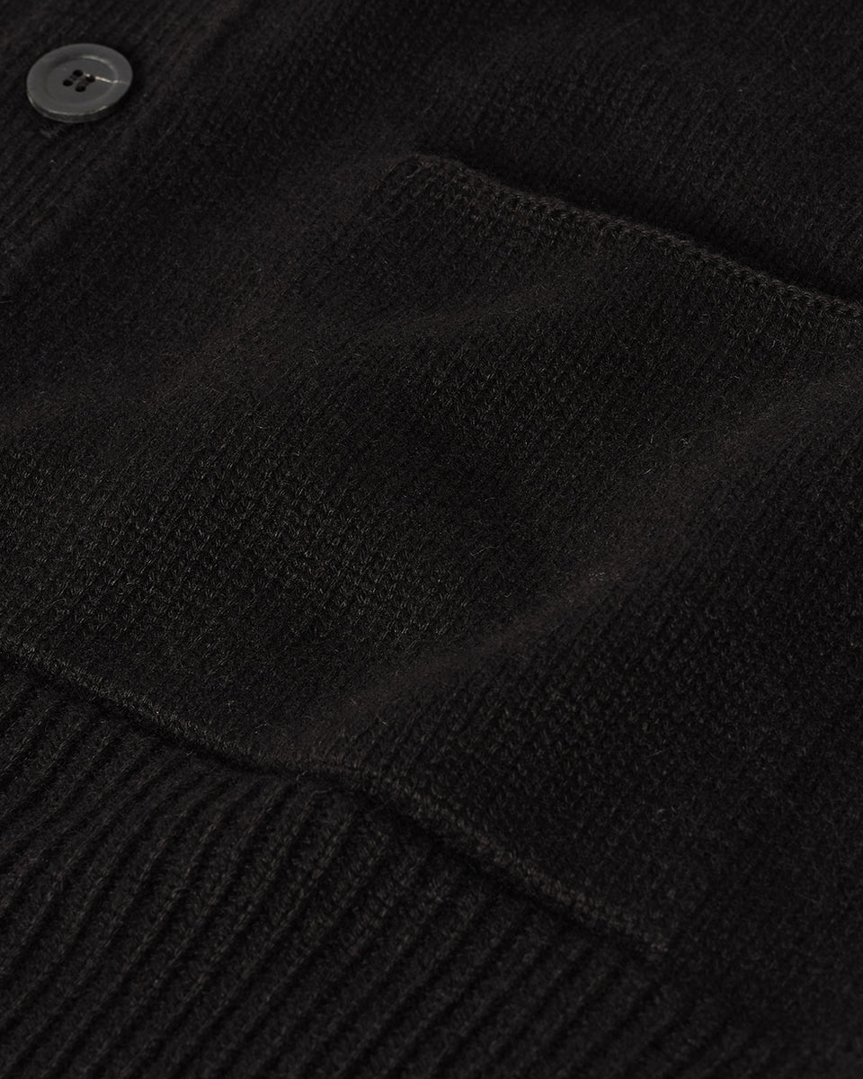 Johnstons of Elgin AW25 Men's Knitwear Black Ribbed Cashmere Black Cardigan worn over a black t-shirt, showing button details  KAC05601SA7210