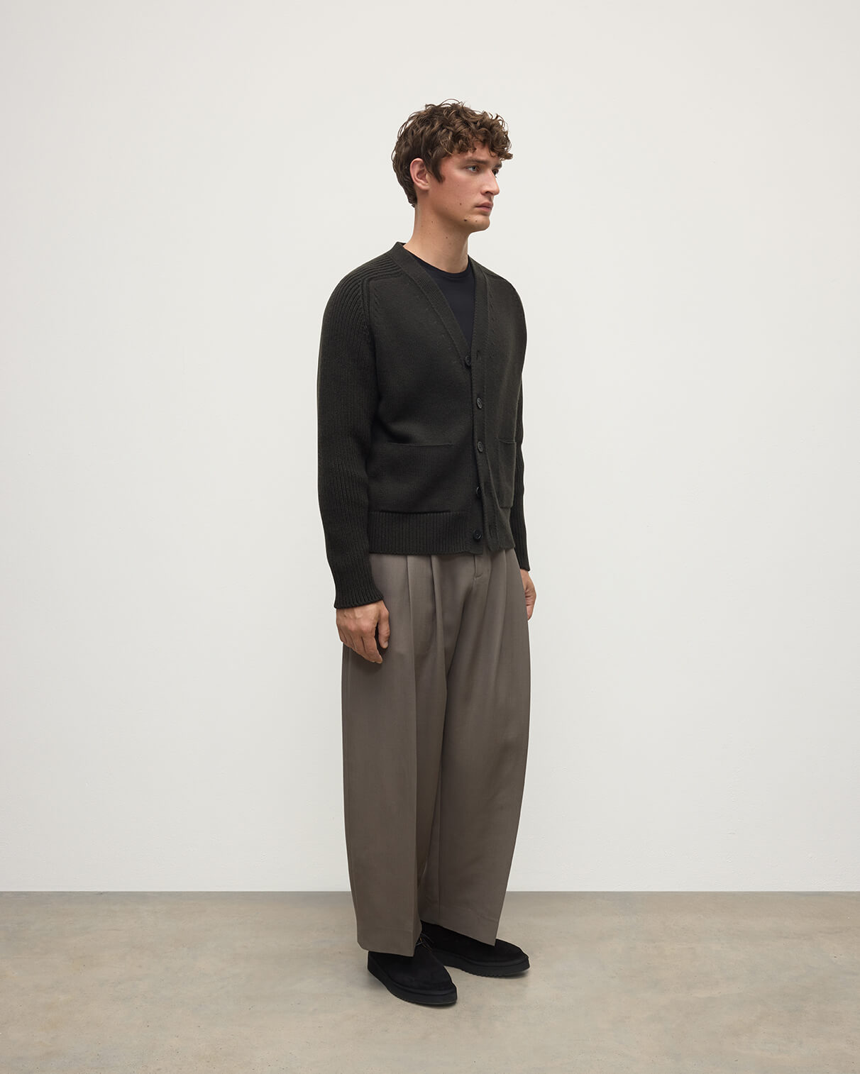 Model wears Johnstons of Elgin AW25 Men's Knitwear Iron Ribbed Cashmere Grey Cardigan Side KAC05601SC7330