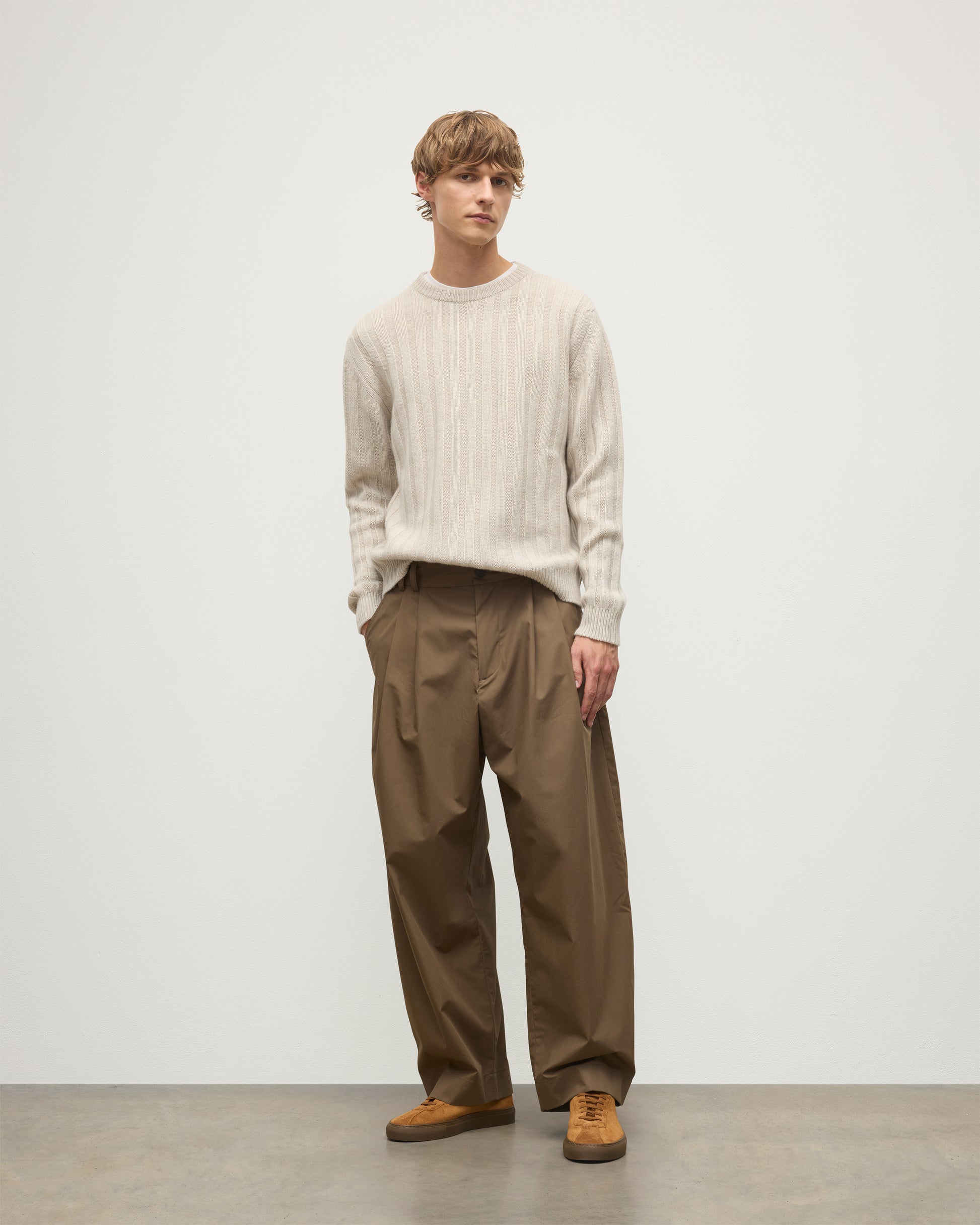 JOHNSTONS OF ELGIN MENS PEEL CREW SWEATER NATURAL 100% CASHMERE ON A MODEL OVER A WHITE T-SHIRT WITH BROWN TROUSERS KAC05751HA0402