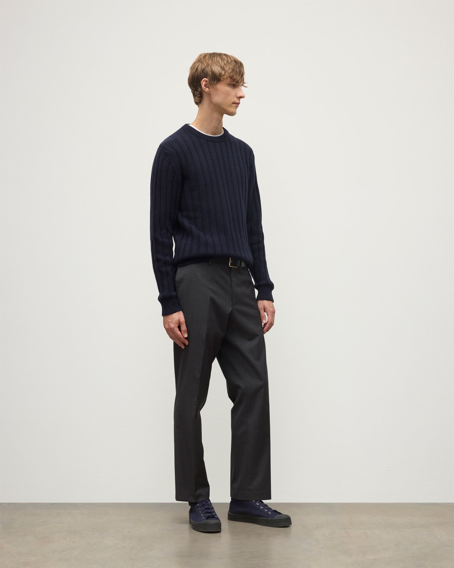 MODEL WEARS JOHNSTONS OF ELGIN MENS PEEL CREW SWEATER NAVY OVER A WHITE T-SHIRT WITH GREY TROUSERS KAC05751SD7666