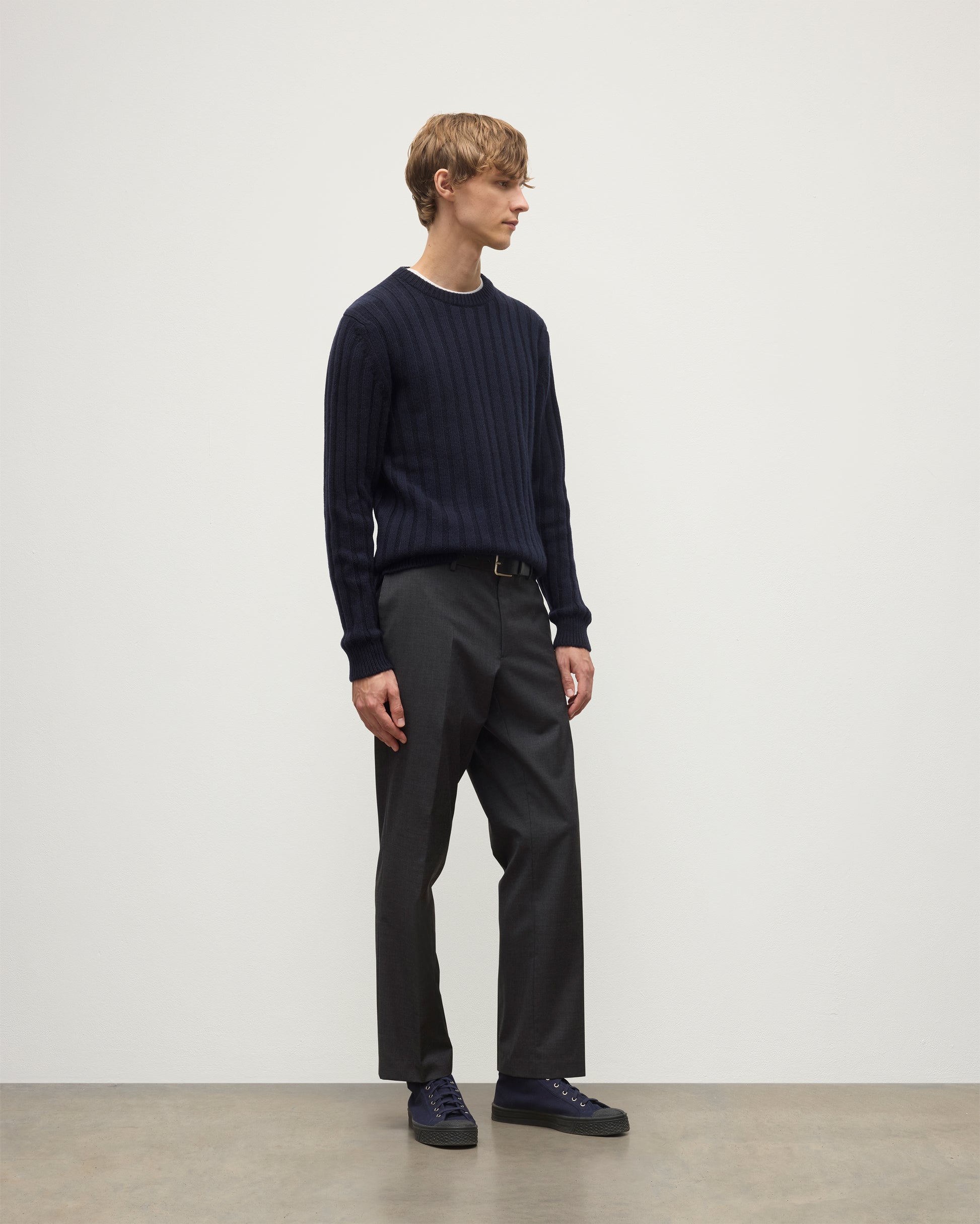 MODEL WEARS JOHNSTONS OF ELGIN MENS PEEL CREW SWEATER NAVY OVER A WHITE T-SHIRT WITH GREY TROUSERS KAC05751SD7666