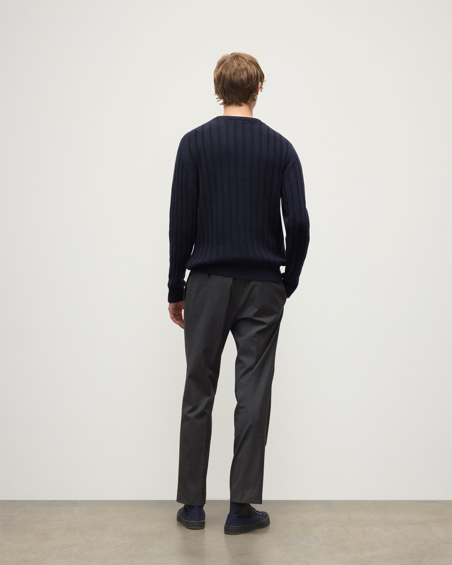 MODEL WEARS JOHNSTONS OF ELGIN MENS PEEL CREW SWEATER NAVY OVER A WHITE T-SHIRT WITH GREY TROUSERS KAC05751SD7666