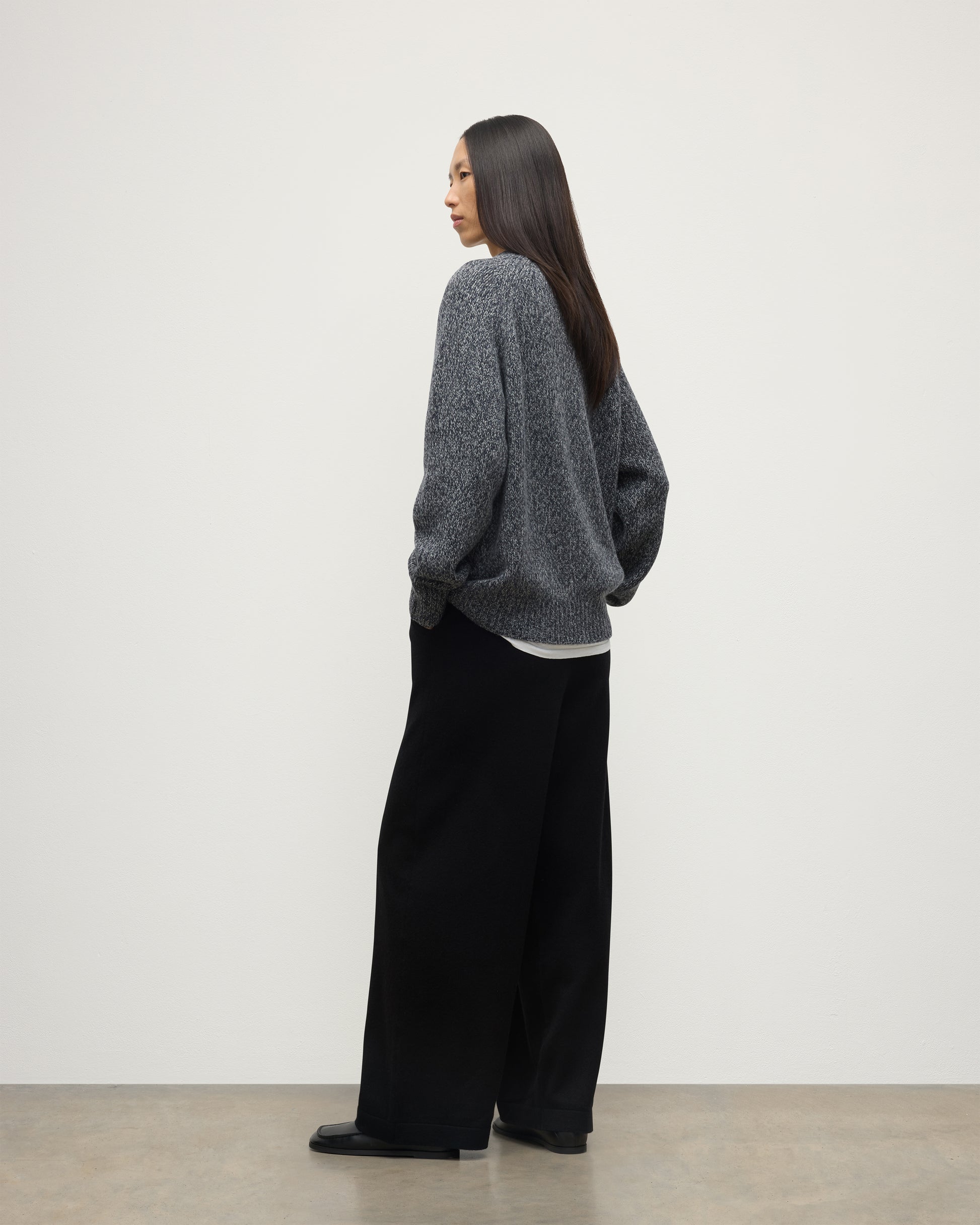 BACK OF FEMALE MODEL WEARS JOHNSTONS OF ELGIN FYFE CREW SWEATER NAVY 100% CASHMERE WITH BLACK TROUSERS UAC05753006876