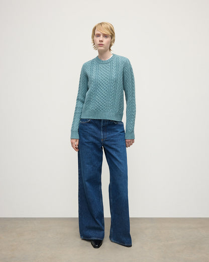 Model wears Johnstons of Elgin AW25 Women's Knitwear Seascape Aran Cable Green Cashmere Jumper Front View KAI05086HC0038